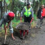 Menjalin Sinergritas, Kanit Binmas Polsek Kasembon Polres Batu Membantu Warga Memperbaiki Jalan